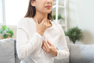 Fototapeta premium Acid reflux disease, suffer asian young woman have symptom gastroesophageal, esophageal, stomach ache and heartburn pain hand on chest from digestion problem after eat food, Healthcare medical concept