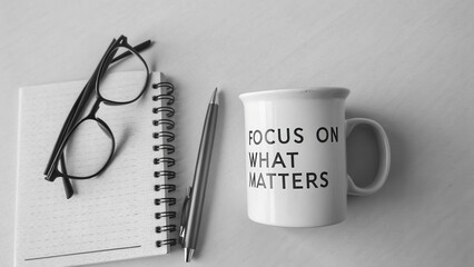 Inspirational workspace with cup, pen, glasses, and notepad to encourage focus and motivation for productivity
