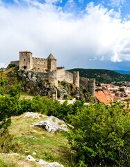 Obraz premium Medieval Fortress Perched Atop a Rocky Hillside