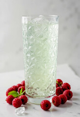 Refreshing raspberry drink with ice in a decorative glass