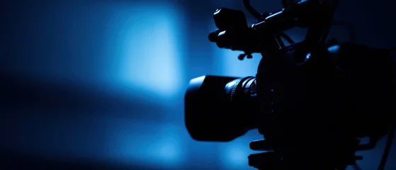 The camera silhouette in moody blue light creating cinematic studio atmosphere and focus © Ol