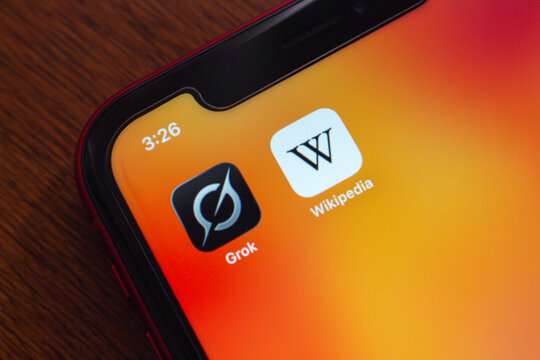 Quito, ECUADOR - Oct 6 2025 :　Close-up of Grok and Wikipedia apps on a smartphone screen, symbolizing Grokipedia, a next-generation AI-powered encyclopedia.