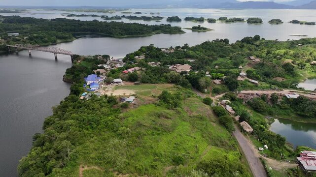 flying across peninsula Akua Yala with village and Bayano Lake, with "Puente Sobre El Bayano" bridge and "Carretera Interamericana" highway, located in Panama - 4k aerial video footage