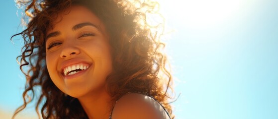 The woman laughing in warm sunlight with curly hair and a radiant smile