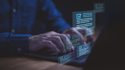 Businessman using laptop computer with glowing checklist documents and forms, symbolizing online...