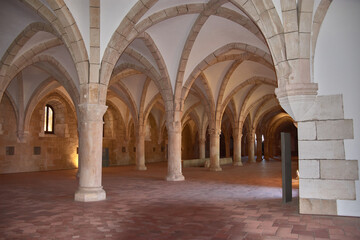Gothic novice dormitory at Alcobaca Monastery with stone columns and a high vault in a historic Portuguese setting