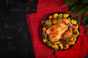 Roasted chicken with potatoes and Christmas decoration. Baked chicken or turkey. Table setting. Top view, flat lay