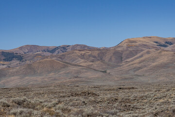Basalt (Pleistocene and Pliocene) Lava Flows with Pioneer Mountains. U.S. Highway 20 (US 20)  / U.S. Highway 26 (US 26) , Martin
, Butte County, Idaho. Snake River Plain. 

