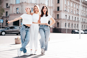 Three young beautiful smiling hipster female in trendy summer white t-shirt  and jeans clothes....