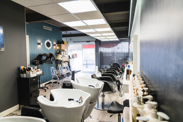 Hairdressing salon interior featuring multiple shampoo basins and styling chairs, waiting for clients. Professional hair care environment