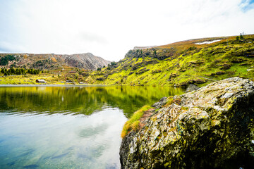 View of Lake Falkert in the Gurktal Alps and the surrounding landscape. Nature at a mountain lake in Carinthia. High mountain lake in Austria.	