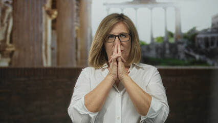 Woman framing hands as gun gesture at sunlit roman building ruins outdoors with blurred marble...