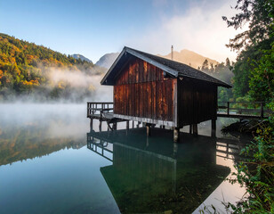Fototapeta premium Lake house reflecting autumn forest