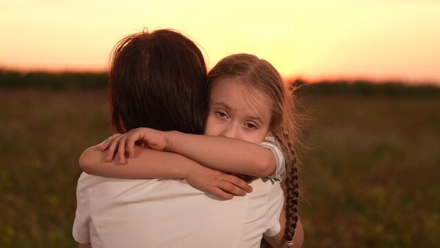Mother child comforting sad daughter at sunset, emotional family moment outdoors, girl child kid hugging mom after a long day, loving embrace nature, parent child support during hard times, expressing