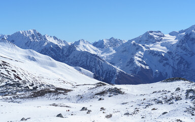 Vast snow covered mountains under a clear blue sky