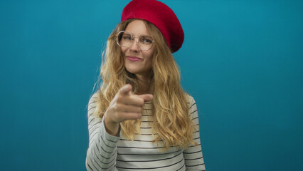 Portrait of a woman whose hand is pointing at the camera in a studio as a blonde young subject...
