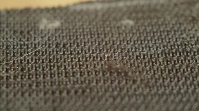 Close macro view of dark textile showing fine weave patterns and rich texture. Perfect for textile, craft, or interior design projects.