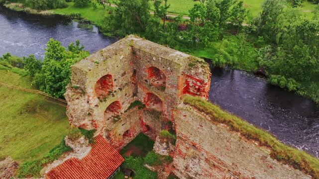 Drone Captures Ruins Of Bauska Castle Walls With Pigeons Above River Memele