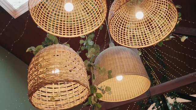 Natural wicker lamps glowing warmly with hanging greenery accents