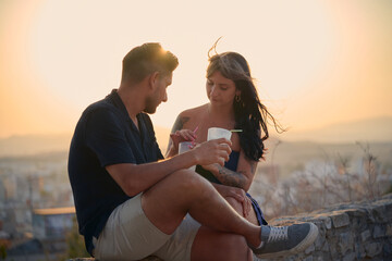 Couple enjoying romantic date with drinks at sunset