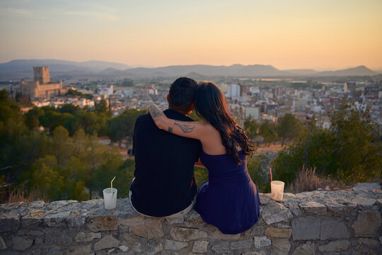 Couple embracing overlooking city at golden hour