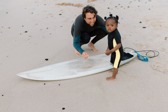 Daughter and Father waxing a surfboard