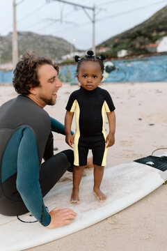 Dad and daughter on a surfboard