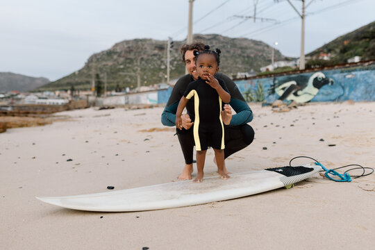 Daddy and daughter surf moment on the beach
