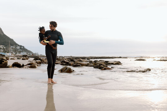 Father carrying his daughter on the beach