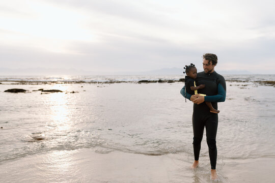 Father and daughter on the beach at sunrise
