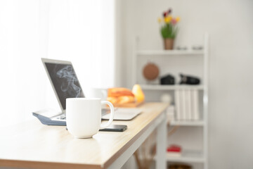 Young woman enjoying a hot drink with eyes closed in a bright room, expressing relaxation, mindfulness, and peaceful morning routine. Ideal for wellness, self-care, and cozy lifestyle themes.