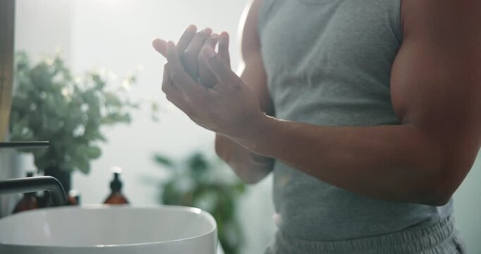 Hands, skincare and cream with man in bathroom for self care, moisturizer or spf cosmetics. Collagen lotion, glow and dermatology with person in home for anti aging treatment and sunscreen protection