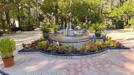 Fountain in the Botanical Garden: A serene fountain, surrounded by vibrant foliage and lush...