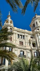 Architectural Grandeur: A stunning building in a sunlit location, the building's intricate architectural details are highlighted, emphasizing its elegance against a clear, cloudless sky. 