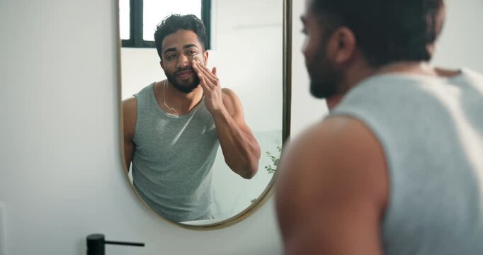 Man, mirror and lotion for skincare in bathroom for hydration, facial sunscreen and natural shine. Male person, reflection and face cream for dermatology, moisturizing treatment and grooming at house