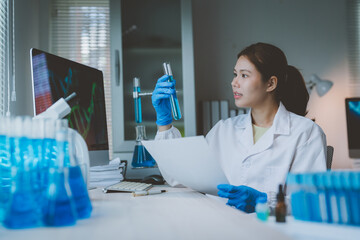 Scientist analyzing liquid in test tube with dna on screen