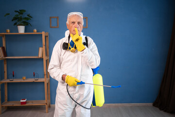 portrait of Elderly pest control worker killing insects inside infested house keep it quiet secret...
