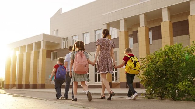 School life and education concept photo, Brother and sister accompanied to school, Excited kids ready for learning day, Students entering educational facility together, Modern architecture school with