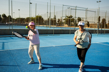 Senior women enjoying active tennis playing on court