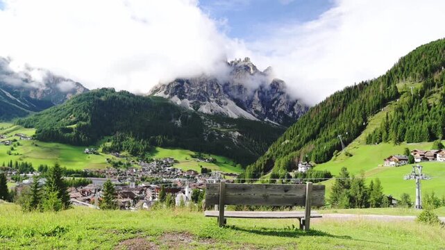 Santa Maddalena church and valley in Val di Funes, South Tyrol Idyllic mountain village with green fields and snowy Dolomites under blue sky