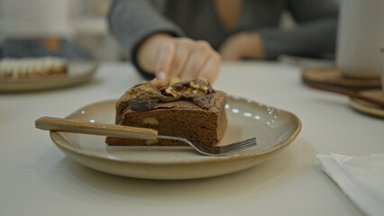 Woman enjoying dessert in modern restaurant with a fork on a plate, capturing the essence of luxury dining and culinary indulgence.
