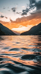 Stunning golden hour landscape over a serene mountain lake at sunset.
