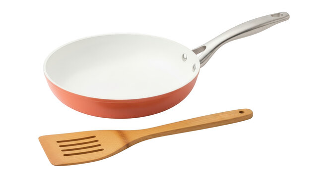 Orange frying pan with wooden spatula isolated on transparent background
