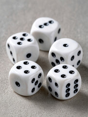 Five white dice with black dots on a textured surface.