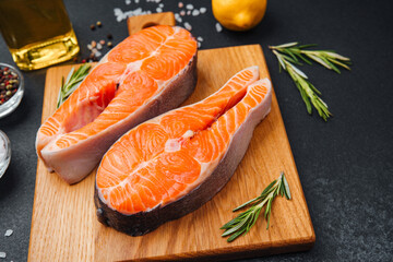 Freshly cut salmon fillets prepared for cooking with herbs and lemon slices