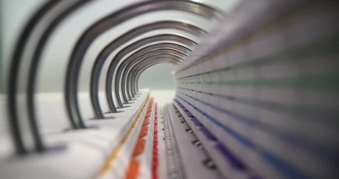 Office worker slowly flips through pages in thick folder carefully examining documents for important details. Worker absorbs printed information