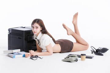 Asian pretty young cute woman confident long hair in office costume sitting on floor poses playfully beside large printer books keyboard landline phone in white studio fashion stylish emotion concept.