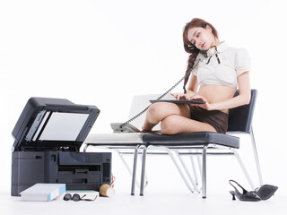 Asian pretty young woman confident braided hair in office costume sitting on bench talk corded landline phone, pose beside large printer books sunglasses keyboard shoes in white studio fashion setting