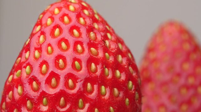A detailed macro view of a fresh red strawberry's surface. This close-up reveals the fruit's vibrant texture, skin, and seeds, ideal for food, health, or abstract backgrounds.