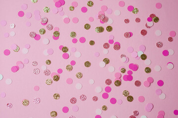 Colorful confetti scattered on a pink background for festive celebrations